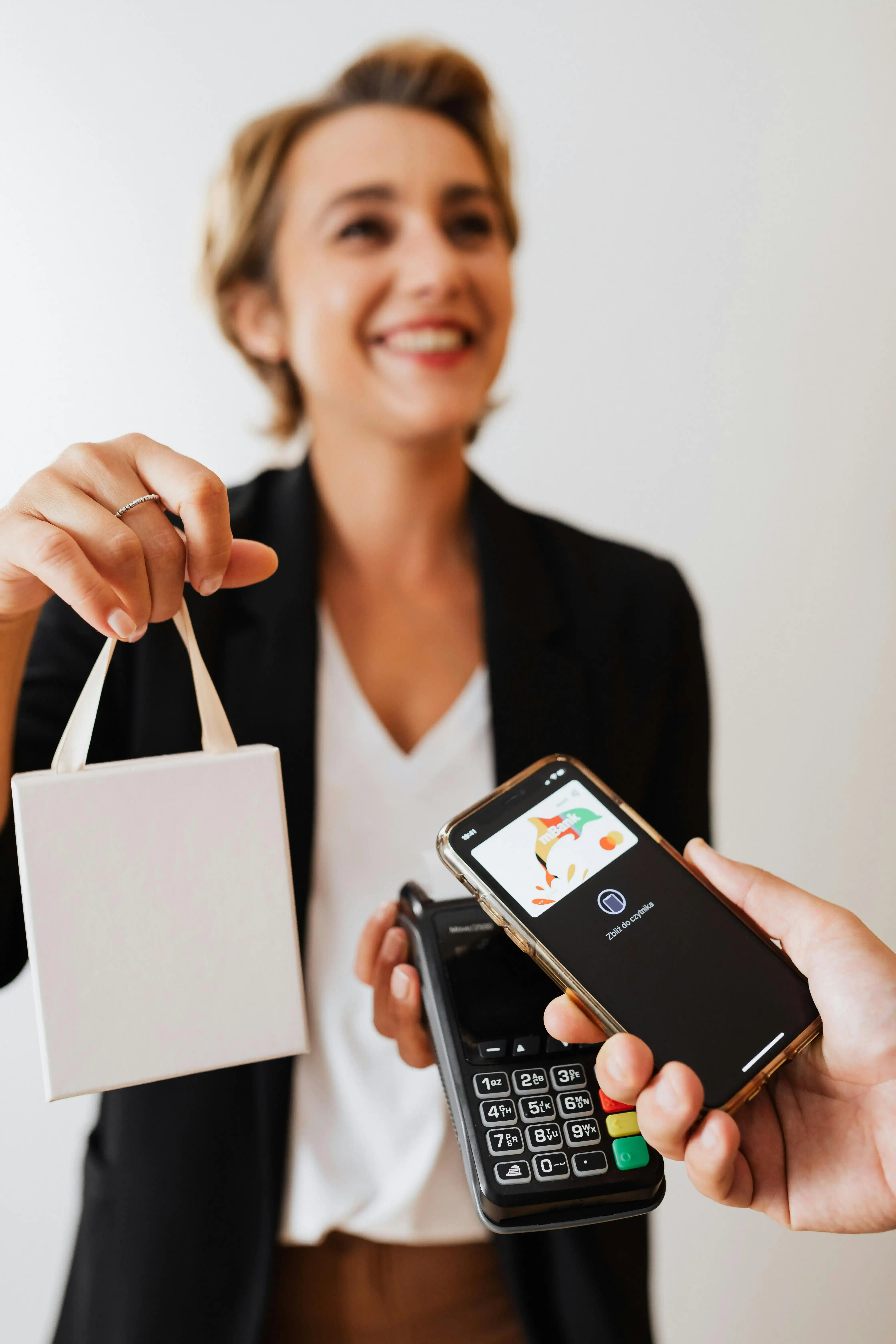 Woman using smartphone for contactless payment at a boutique counter