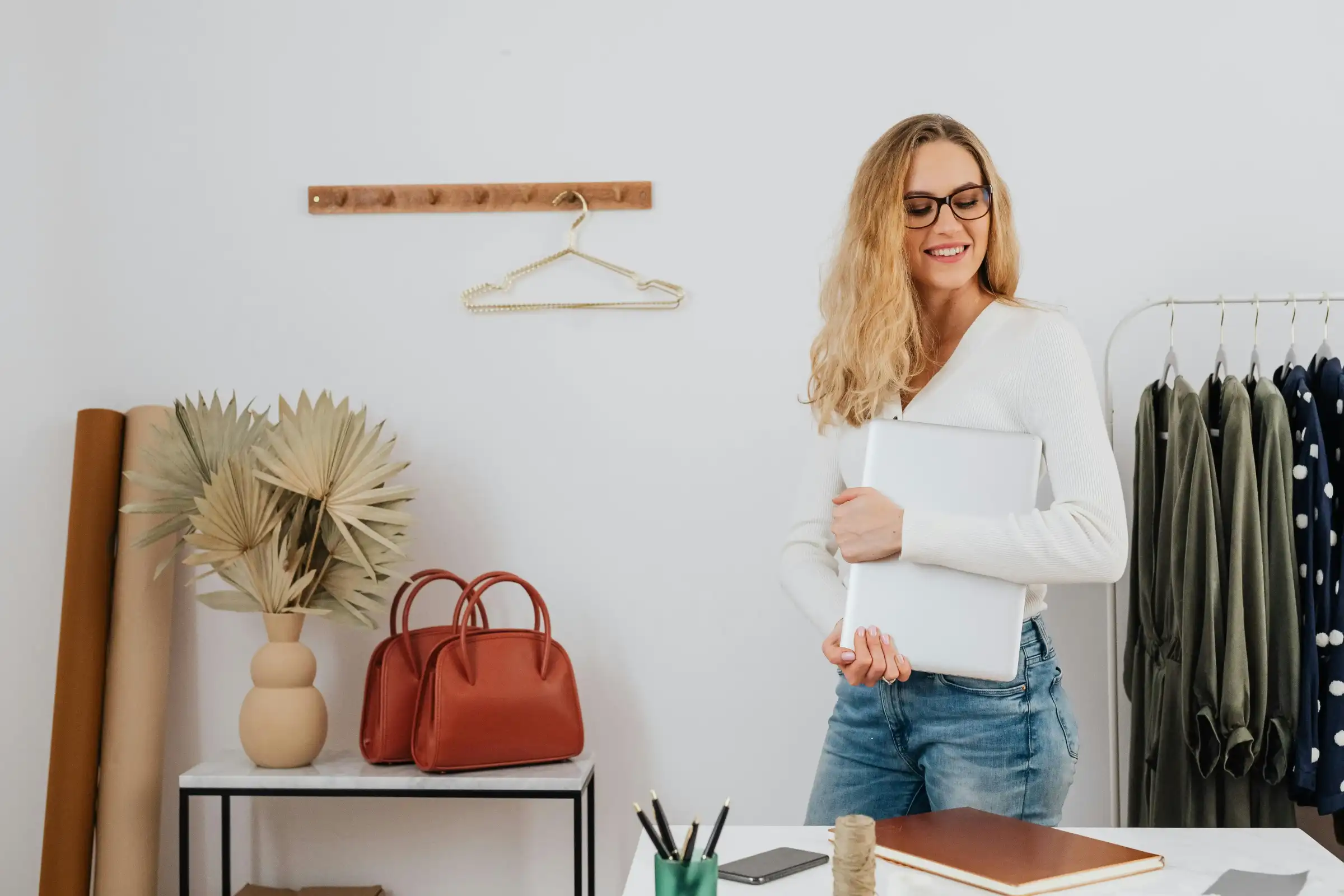 Fashion boutique owner with laptop in a stylish store